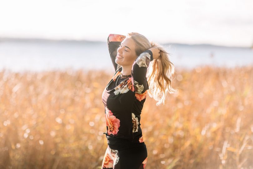 Ny blogg hos MåBra. My står på en åker och har på sig träningskläder. Svarta med röda blommor.