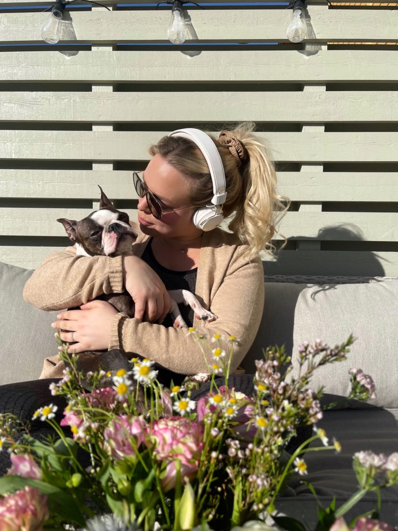 Sudio Nio och Regent 2. My sitter på sin uteplats med Svea hennes hund. De sitter och njuter i solen med blommor, kaffe och ljudbok.