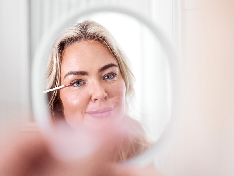 My Martens använder Swiss Clinic ögonfransserum Eyelash Growth Serum. Hon använder en spegel för att applicera serumet på sina fransar.